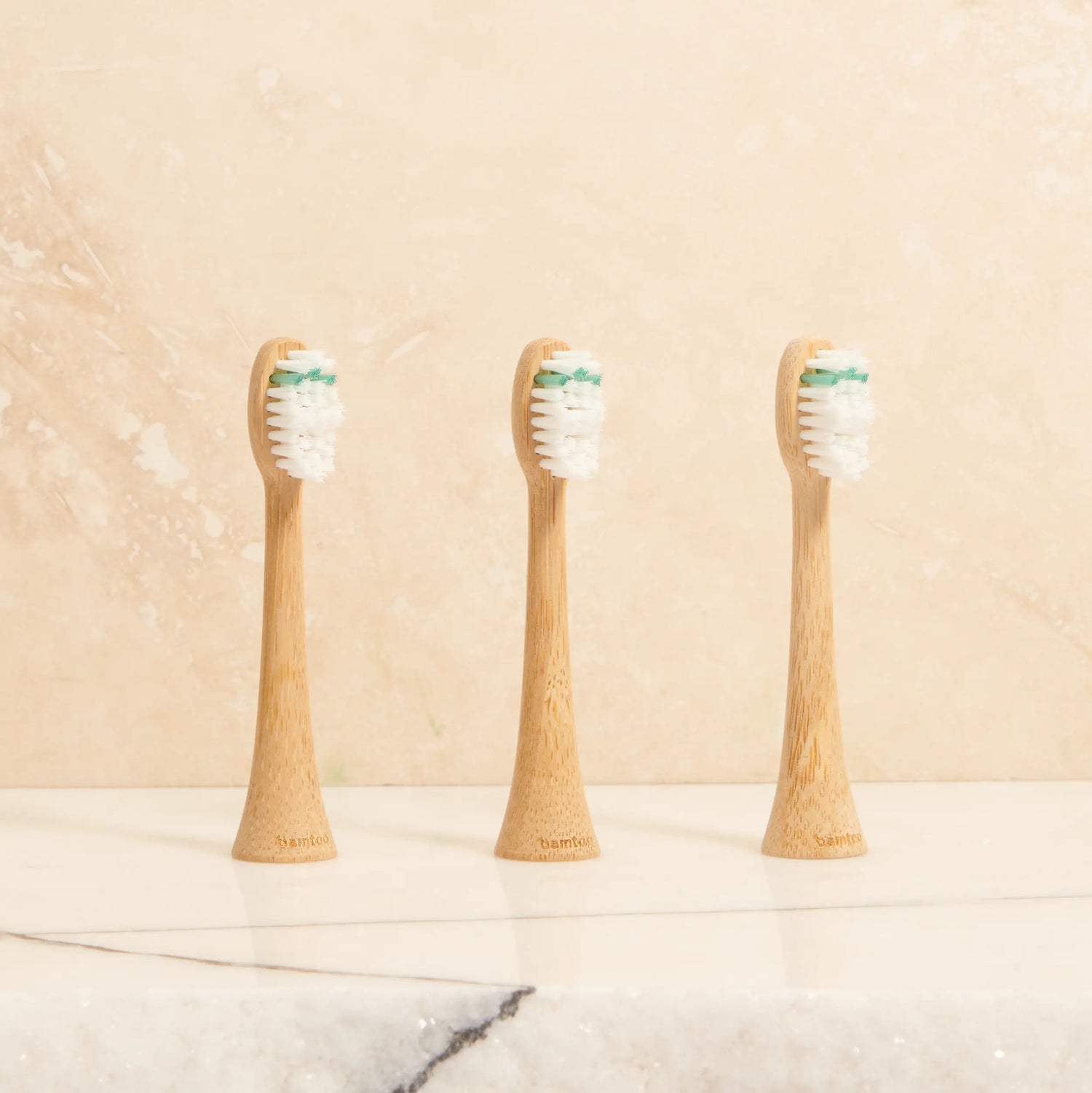 Zahnbürstenaufsätze aus Bambus vor beigem Hintergrund für die Schallzahnbürste KOA V2 von bamtoo
